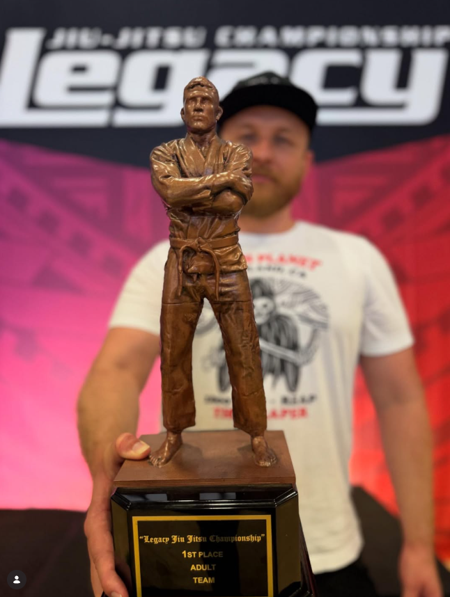 Michael Hillebrand holding the first place Adult Team trophy after 10th Planet Oakland won the 2025 Legacy Jiu Jitsu Championship
