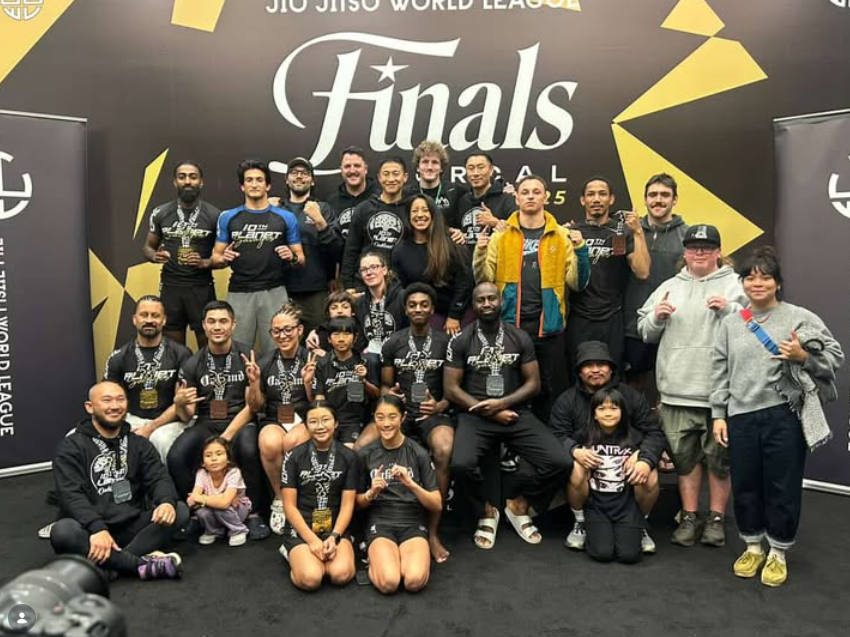 10th Planet Oakland team members posing with medals in front of the 2025 JJWL Finals NorCal backdrop