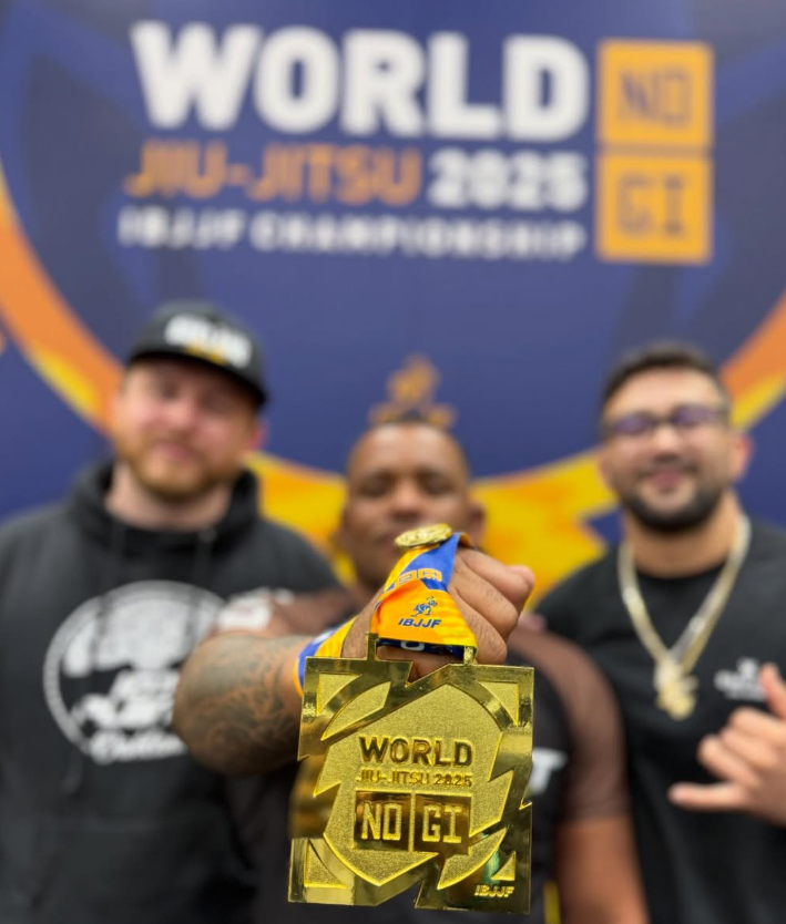 Joseph Garner holding his gold medal with two others at the 2025 IBJJF No-Gi Worlds